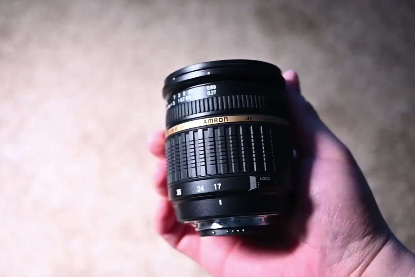 Hand holding a Tamron lens