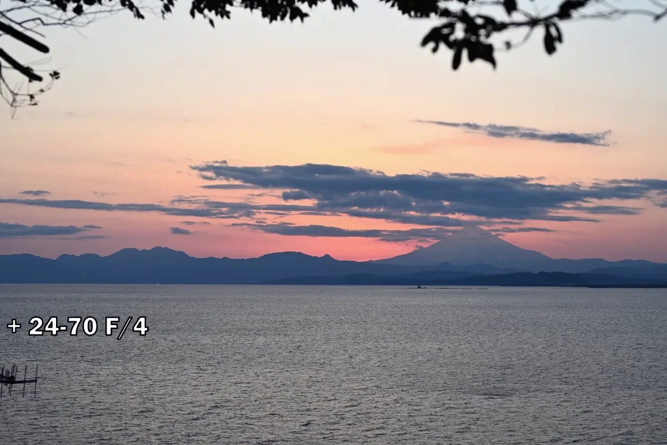 Sunset over a bay with mountains in the background shot at 45mm