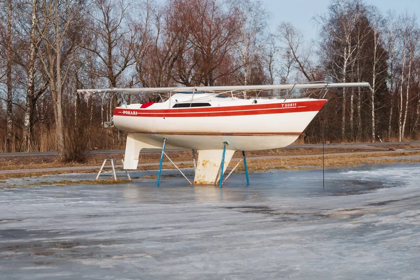 A white sailboat resting on a frozen surface