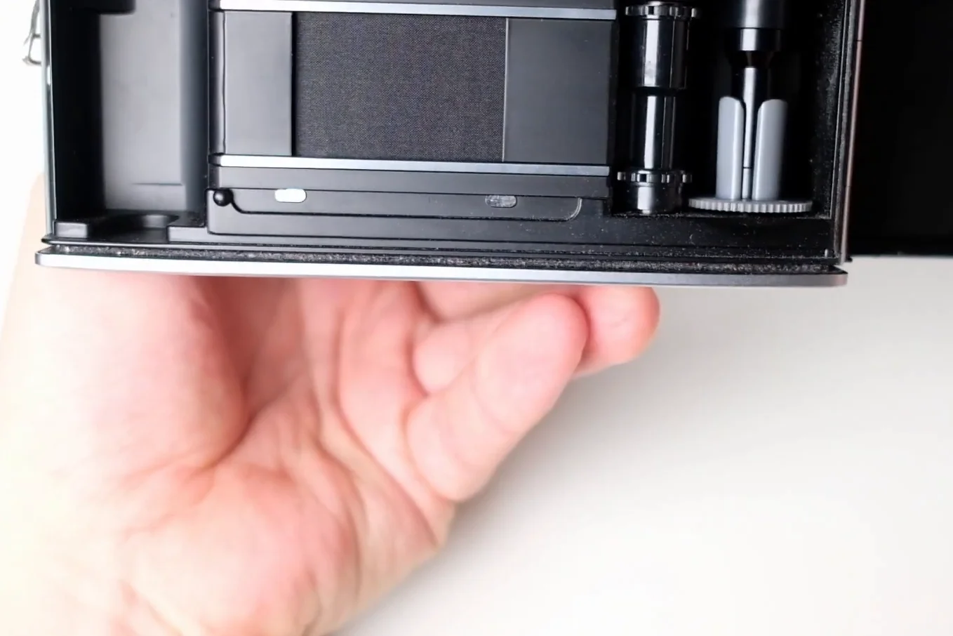 Open back of the camera showing the film curtain and spool